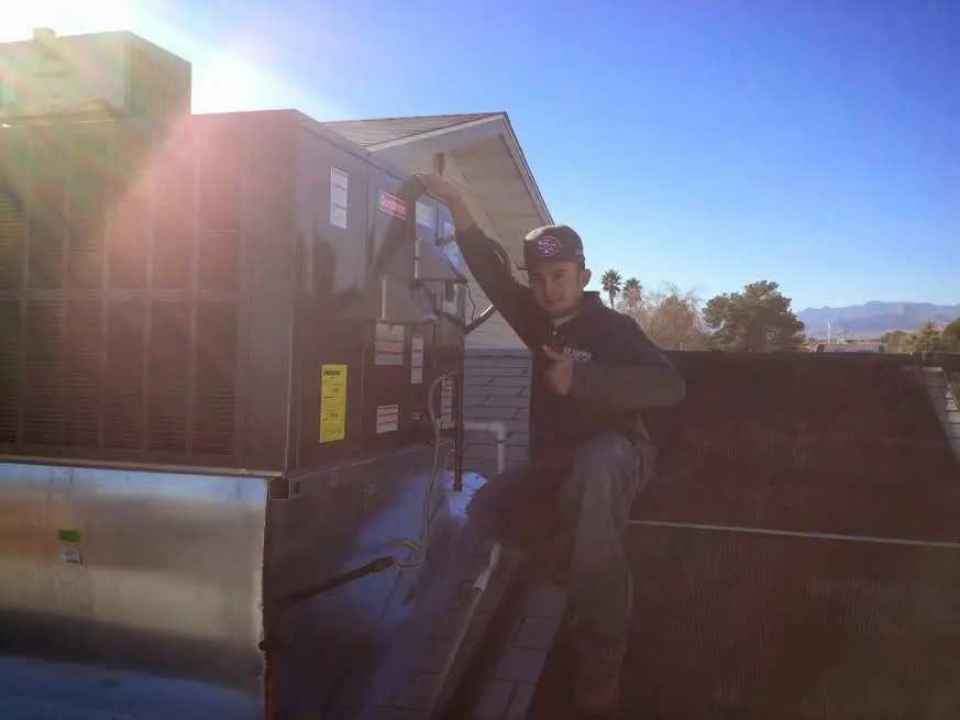 HVAC technician performing HVAC Inspection on a rooftop unit in Waterloo